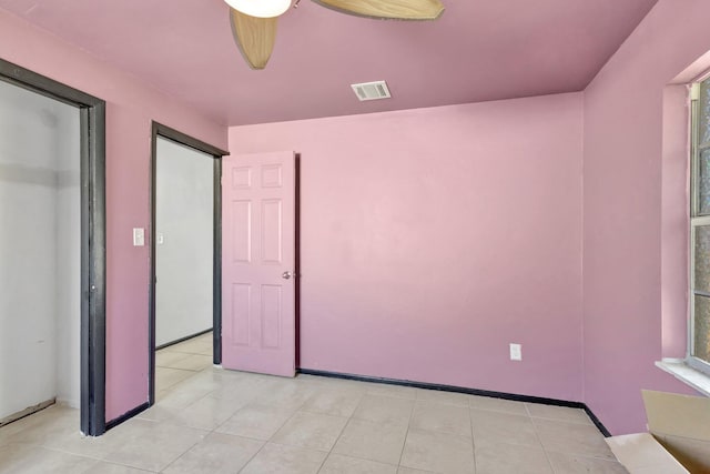 unfurnished bedroom with visible vents, baseboards, a ceiling fan, and light tile patterned flooring
