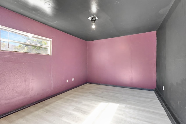 empty room featuring baseboards and wood finished floors