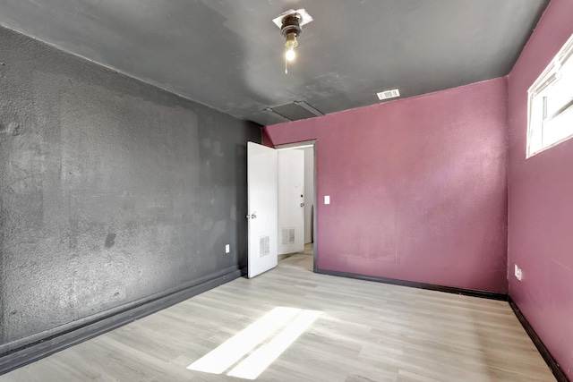 unfurnished room featuring visible vents and wood finished floors
