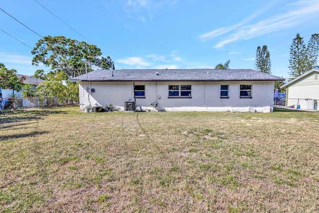 rear view of house with a yard, fence, and central air condition unit