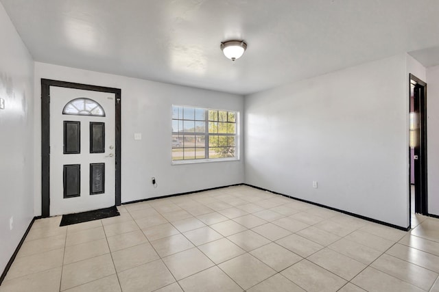 foyer entrance with light tile patterned floors and baseboards