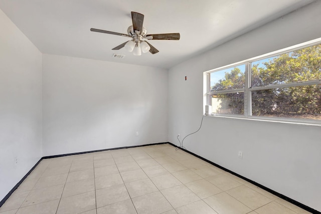 empty room featuring ceiling fan, baseboards, and visible vents