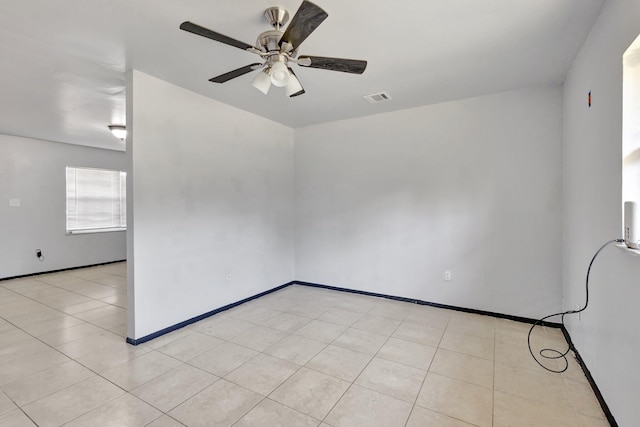 spare room featuring baseboards, a ceiling fan, and visible vents
