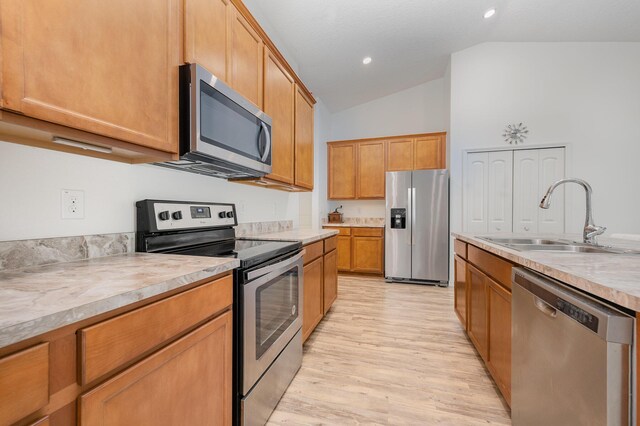 1544 Summit Rd SE, Palm Bay, FL 32909 - kitchen featuring light wood-style flooring, a sink, stainless steel appliances, light countertops, and vaulted ceiling