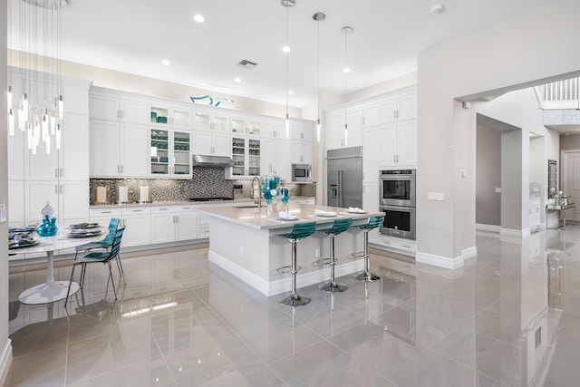 16202 Cabernet Dr, Delray Beach, FL 33446 - kitchen featuring a kitchen breakfast bar, a sink, visible vents, light countertops, and appliances with stainless steel finishes