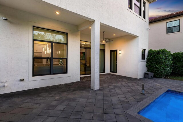 16202 Cabernet Dr, Delray Beach, FL 33446 - patio terrace at dusk with a fenced in pool and a ceiling fan