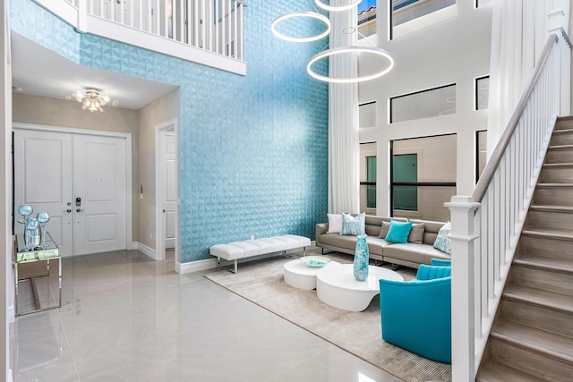 16202 Cabernet Dr, Delray Beach, FL 33446 - living area with stairs, baseboards, a high ceiling, and a notable chandelier