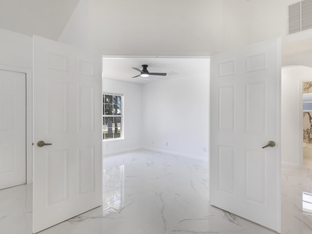 1201 SW Paar Dr, Port Saint Lucie, FL 34953 - empty room featuring a ceiling fan, baseboards, marble finish floor, visible vents, and arched walkways