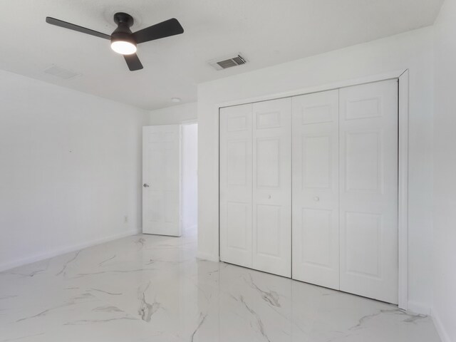 1201 SW Paar Dr, Port Saint Lucie, FL 34953 - unfurnished bedroom featuring a closet, baseboards, marble finish floor, visible vents, and ceiling fan
