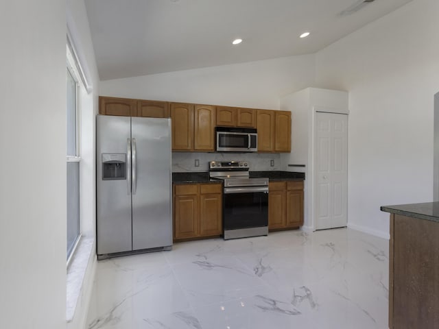 1201 SW Paar Dr, Port Saint Lucie, FL 34953 - kitchen with brown cabinetry, high vaulted ceiling, baseboards, dark countertops, and appliances with stainless steel finishes