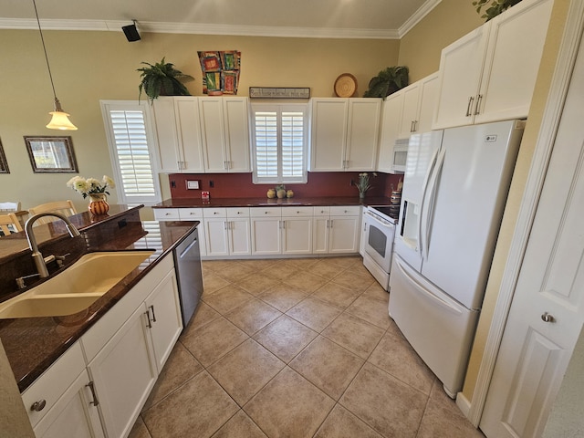 411 NW Stratford Ln, Port Saint Lucie, FL 34983 - kitchen featuring white appliances, a sink, dark countertops, white cabinets, and ornamental molding