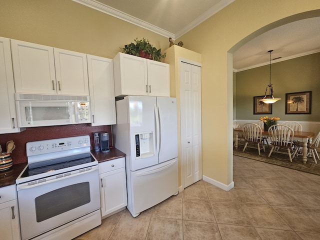 411 NW Stratford Ln, Port Saint Lucie, FL 34983 - kitchen with white appliances, dark countertops, crown molding, arched walkways, and white cabinetry