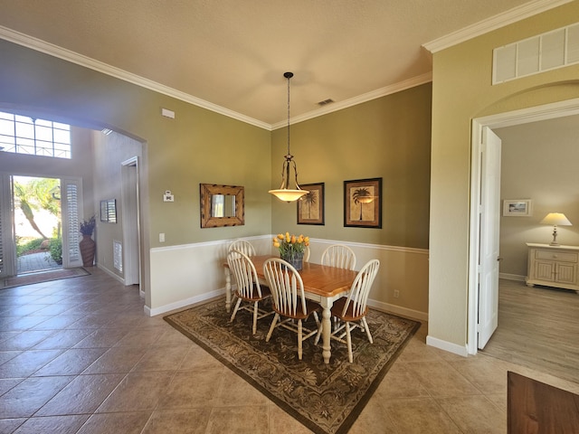 411 NW Stratford Ln, Port Saint Lucie, FL 34983 - dining area featuring crown molding, arched walkways, baseboards, and light tile patterned floors