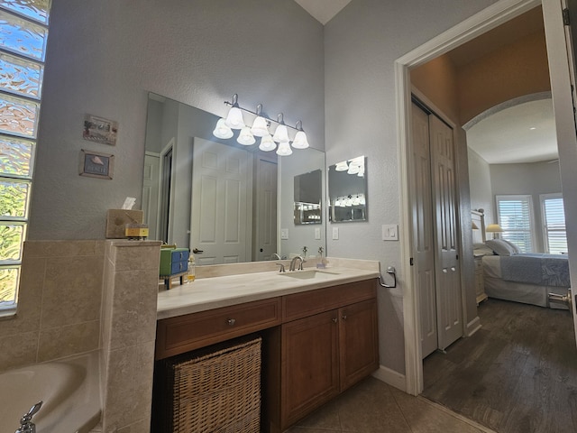 411 NW Stratford Ln, Port Saint Lucie, FL 34983 - full bath featuring a textured wall, vanity, connected bathroom, a garden tub, and tile patterned floors
