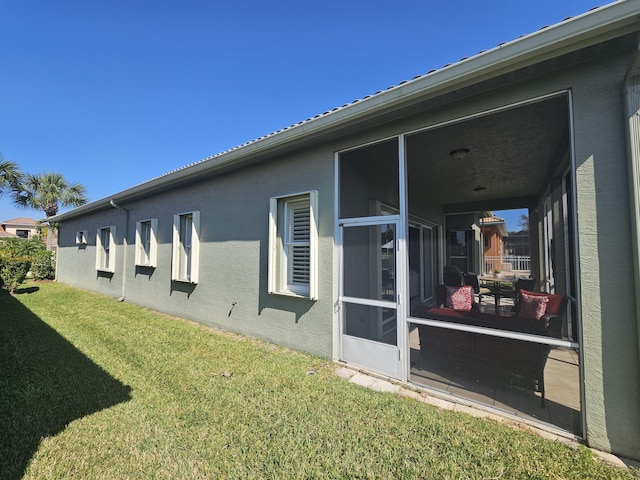 411 NW Stratford Ln, Port Saint Lucie, FL 34983 - view of side of home with a lawn, stucco siding, and a sunroom