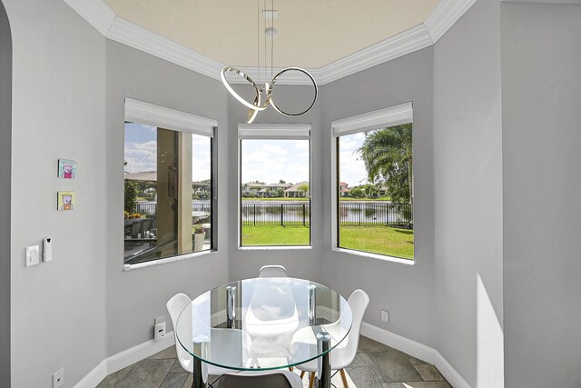 dining room with ornamental molding, a water view, and plenty of natural light