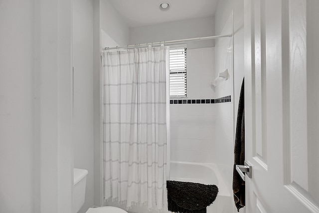 full bathroom with shower / bath combo with shower curtain and toilet