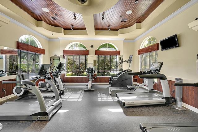 gym with wooden ceiling, a wealth of natural light, and crown molding