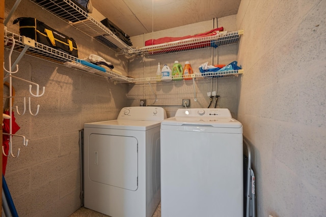washroom with washer and dryer, laundry area, and concrete block wall
