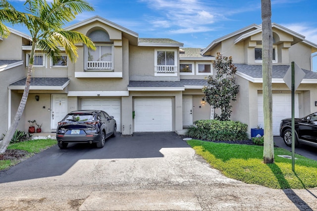 2190 Discovery Cir W, Deerfield Beach, FL 33442 - view of property with a shingled roof, driveway, stucco siding, and an attached garage