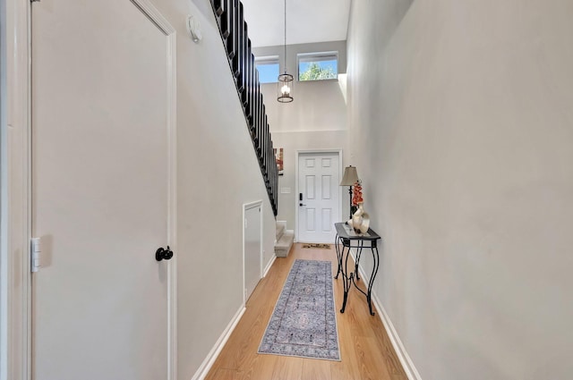 2190 Discovery Cir W, Deerfield Beach, FL 33442 - corridor with stairway, a towering ceiling, light wood-type flooring, and baseboards