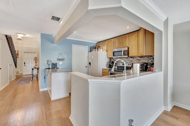 2190 Discovery Cir W, Deerfield Beach, FL 33442 - kitchen featuring light wood-style floors, a textured ceiling, visible vents, appliances with stainless steel finishes, and backsplash