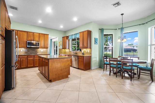 8207 Venosa Haven Ter, Boynton Beach, FL 33473 - kitchen with a center island, visible vents, backsplash, and appliances with stainless steel finishes