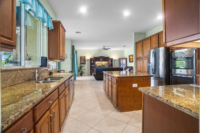 8207 Venosa Haven Ter, Boynton Beach, FL 33473 - kitchen featuring a kitchen island, appliances with stainless steel finishes, dark stone counters, and a sink