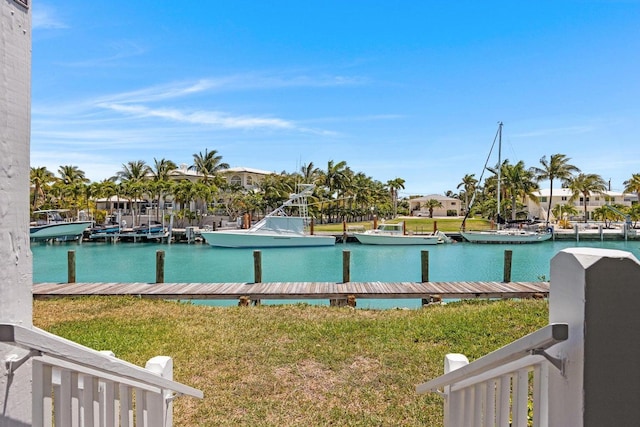 view of pool featuring a lawn, a dock, and a water view