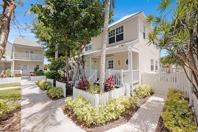 view of front of home featuring covered porch and fence