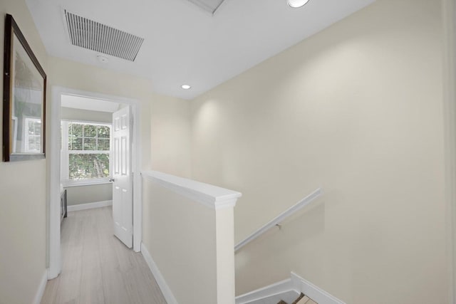 corridor featuring recessed lighting, light wood-style flooring, an upstairs landing, baseboards, and visible vents