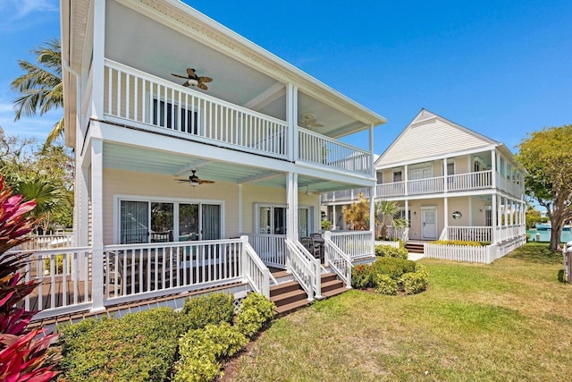 rear view of house with a yard, ceiling fan, covered porch, and a balcony