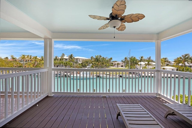 wooden terrace with a ceiling fan and a water view