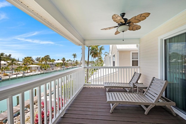 wooden deck with a water view and ceiling fan