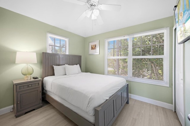 bedroom featuring a ceiling fan, light wood finished floors, and baseboards