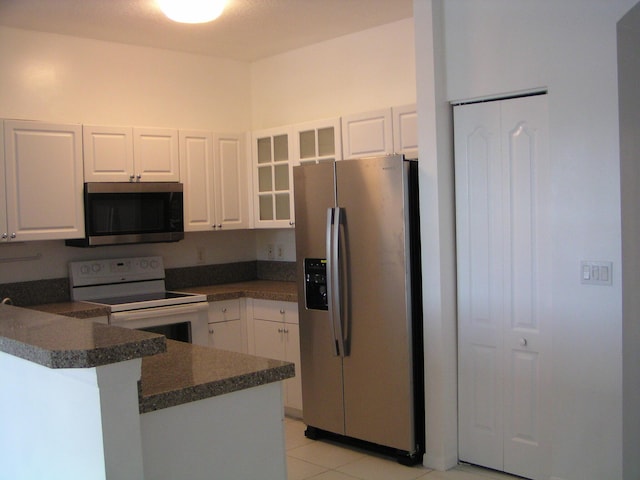 312 River Bluff Ln, Royal Palm Beach, FL 33411 - kitchen with appliances with stainless steel finishes, dark countertops, glass insert cabinets, white cabinets, and a peninsula