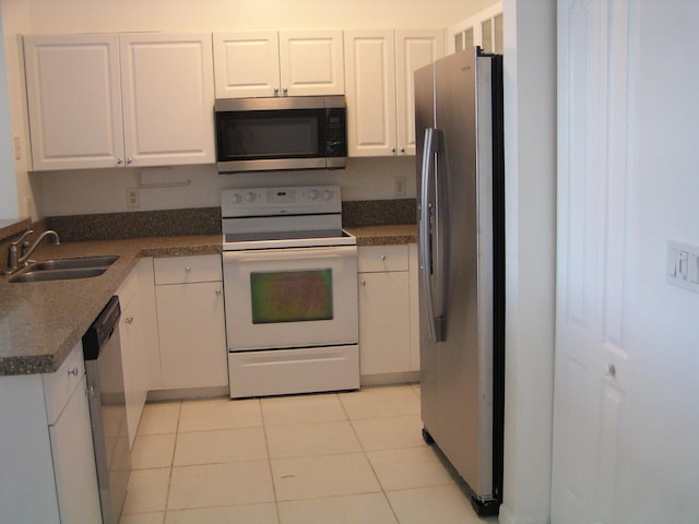 312 River Bluff Ln, Royal Palm Beach, FL 33411 - kitchen featuring stainless steel appliances, light tile patterned floors, white cabinets, and dark countertops