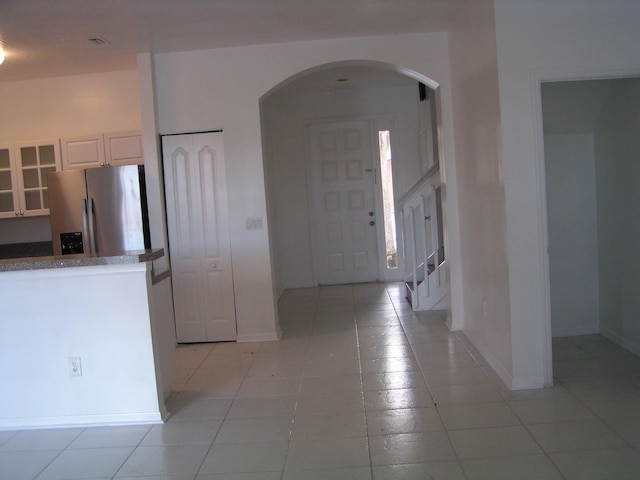 312 River Bluff Ln, Royal Palm Beach, FL 33411 - kitchen with stainless steel fridge, arched walkways, glass insert cabinets, and light tile patterned floors
