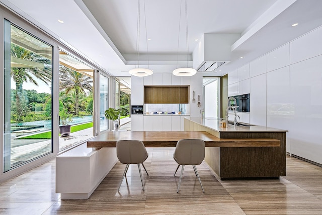 kitchen with white cabinets, modern cabinets, plenty of natural light, and a spacious island