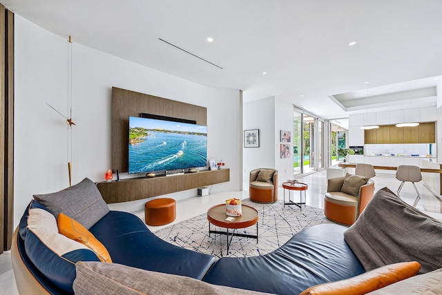 living area featuring a raised ceiling and recessed lighting