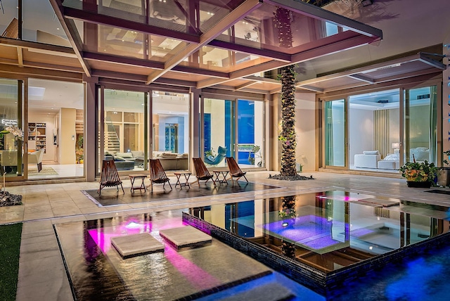back of property featuring a patio area and an outdoor hot tub
