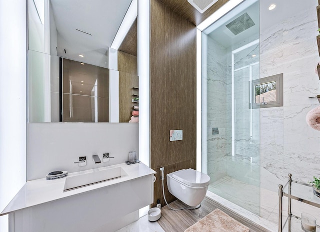 bathroom with toilet, a marble finish shower, and recessed lighting
