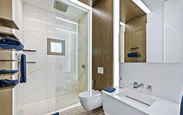 full bathroom featuring a shower stall, a sink, toilet, and wood finished floors