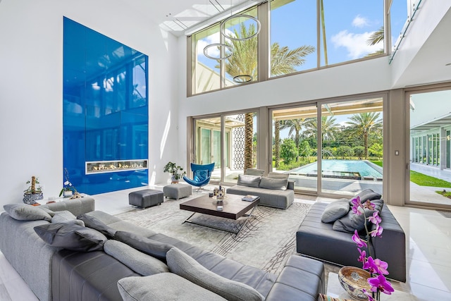 living room with a wealth of natural light, tile patterned floors, and a towering ceiling