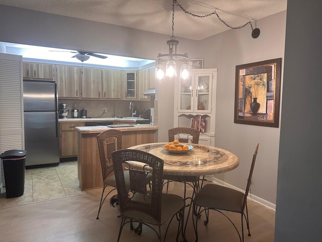 dining area with a ceiling fan and a textured ceiling