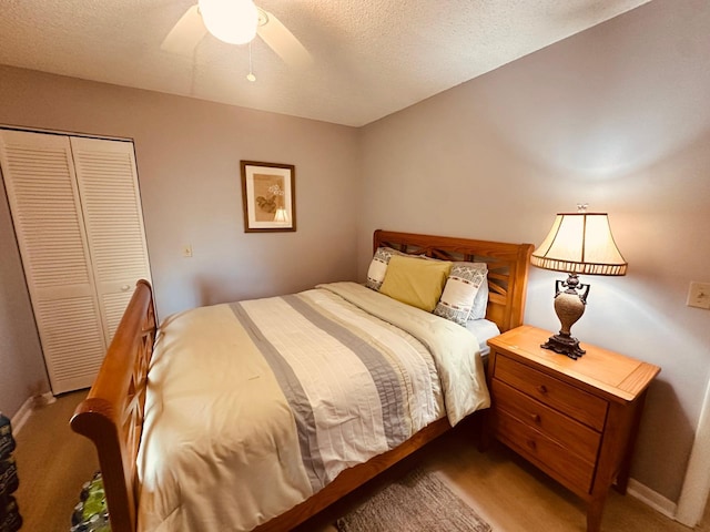 carpeted bedroom with a closet, a textured ceiling, ceiling fan, and baseboards