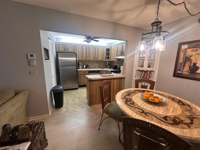 kitchen featuring appliances with stainless steel finishes, a sink, a peninsula, under cabinet range hood, and a ceiling fan