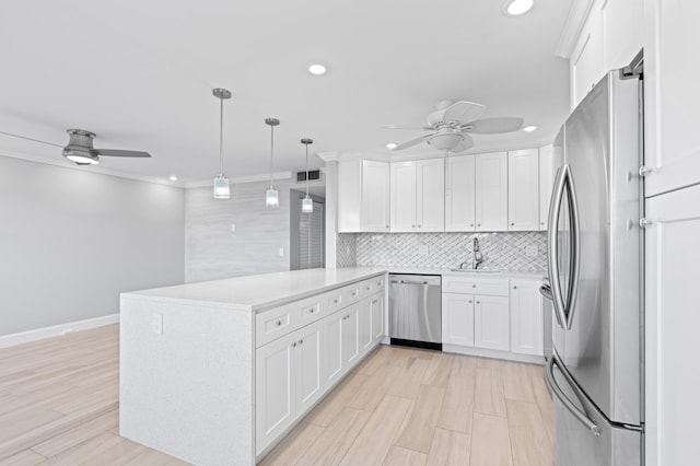 kitchen featuring a peninsula, recessed lighting, backsplash, a ceiling fan, and appliances with stainless steel finishes