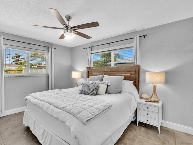bedroom with a textured ceiling, baseboards, and ceiling fan