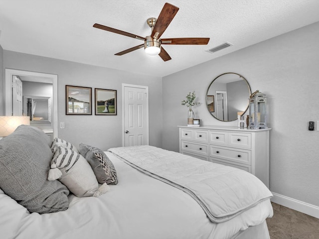 bedroom featuring baseboards, a ceiling fan, visible vents, and a textured ceiling